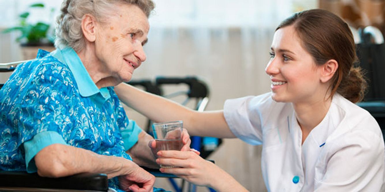 Seniorin mit Pflegerin im Pflegeheim