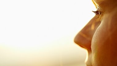 Frau schaut in die Sonne - Foto: iStock/mediaphotos