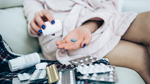 Frau sitzt vor Tabletten - Foto: iStock/Vertigo3d