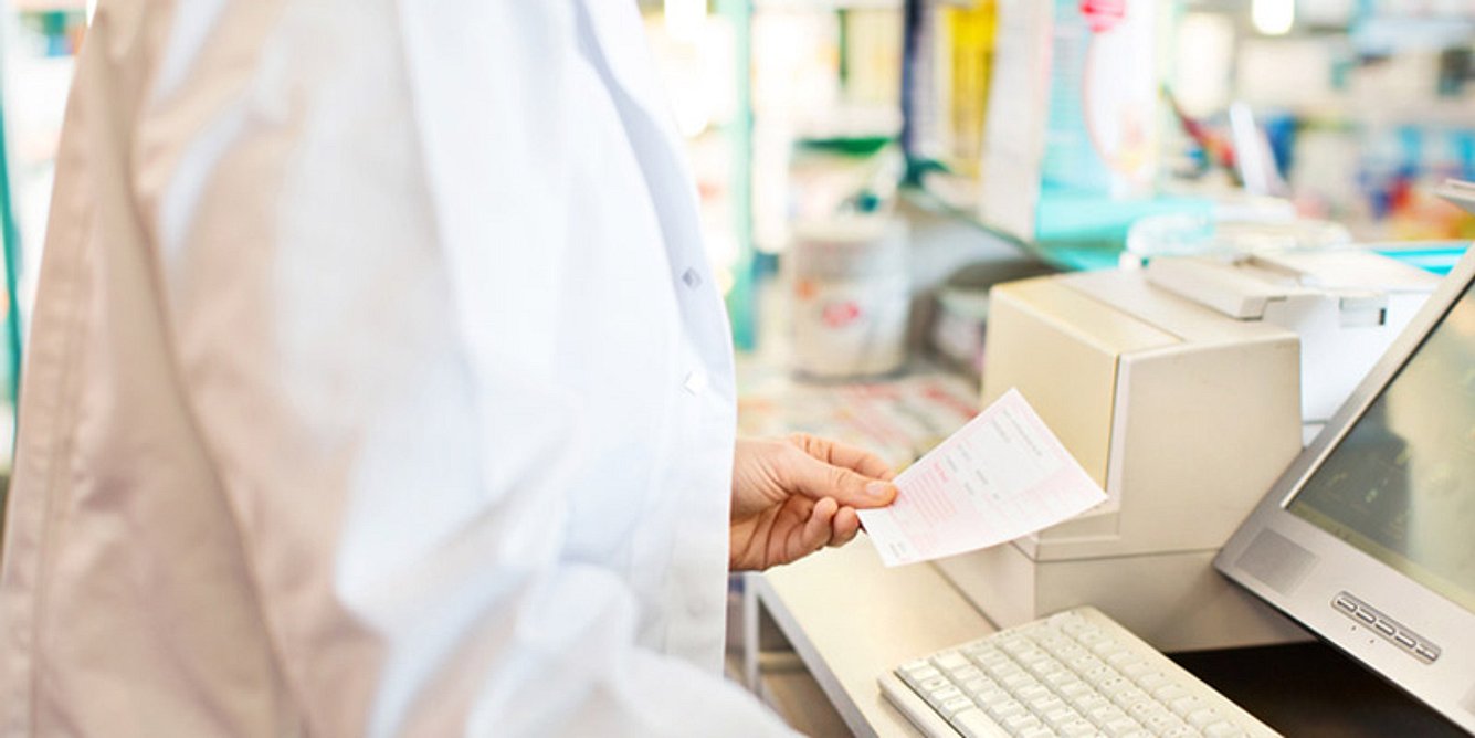 Ein Apotheker hält ein Rezept in der Hand