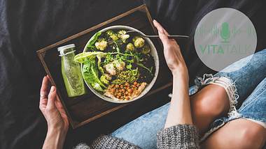 Frau sitzt mit gesunder Bowl auf dem Sofa - Foto: iStock/Foxys_forest_manufacture