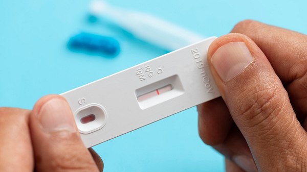 Person hält Corona-Schnelltest in der Hand - Foto: iStock/solidcolours