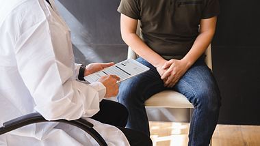 Patient sitzt vor Arzt - Foto: istock/Korrawin