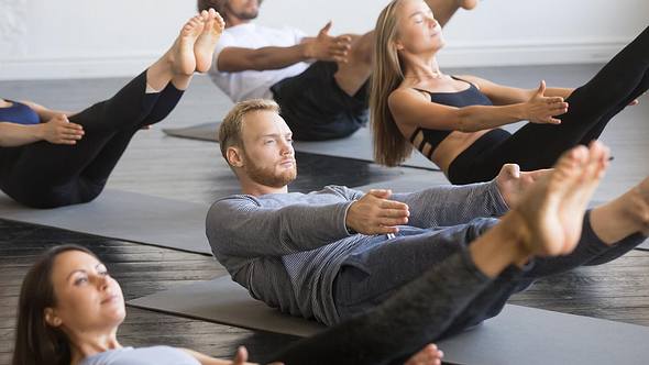 Männer und Frauen machen Yoga. - Foto: iStock/fizkes