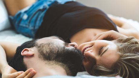 Mann und Frau liegen auf dem Bett und schauen sich an - Foto: iStock/tool51