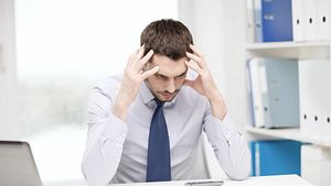 Mann am Schreibtisch stürzt verzweifelt den Kopf in die Hände - Foto: iStock-1266786360 dolgachov