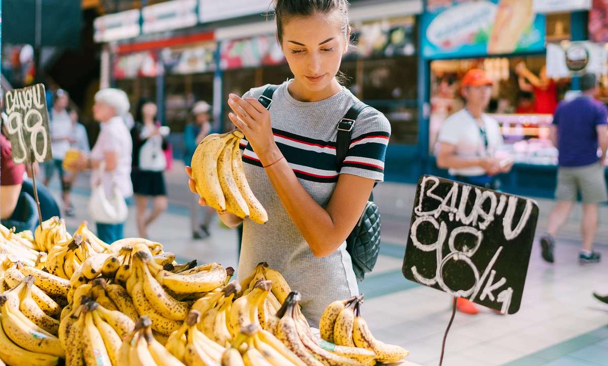 Frau kauft gesunde Bananen auf dem Markt