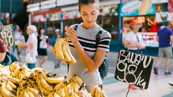 Frau kauft gesunde Bananen auf dem Markt - Foto: iStock/marting-dm
