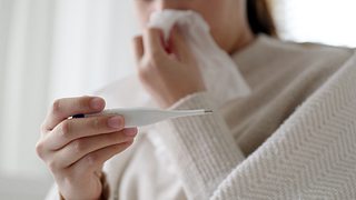 Frau mit Fieberthermometer - Foto: iStock/Chaay_Tee
