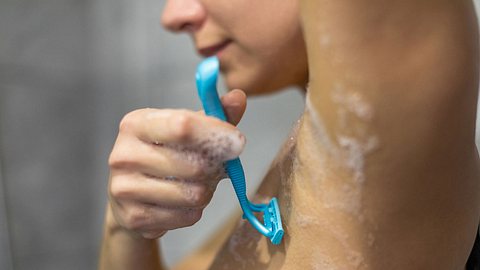 Eine Frau rasiert sich die Achsel unter der Dusche - Foto: iStock/bymuratdeniz