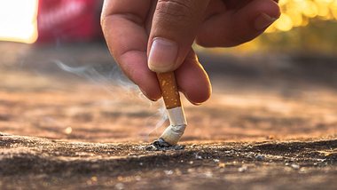 Frau drückt Zigarette auf dem Boden aus. - Foto: iStock/Thinnapat