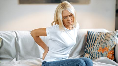 Frau hat durch Reizdarm Rückenschmerzen - Foto: iStock/Kateryna Onyshchuk