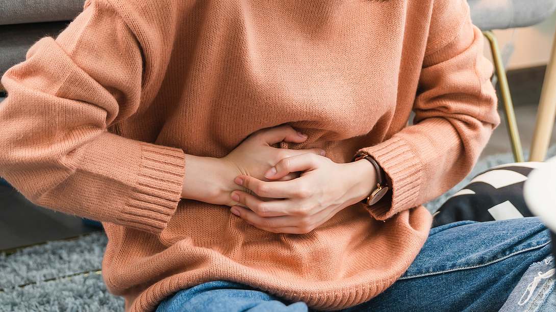 Eine Frau hält sich den Bauch - Foto: iStock/Sitthiphong