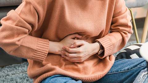 Eine Frau hält sich den Bauch - Foto: iStock/Sitthiphong