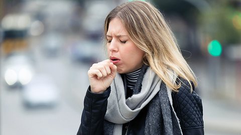 Frau hustet. - Foto: iStock/nensuria