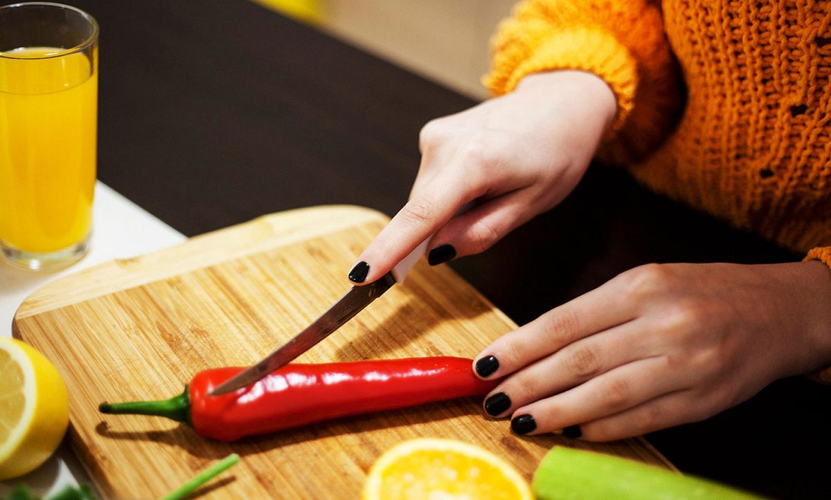 Eine Frau schneidet eine Chili