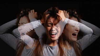 Frau mit Schizophrenie fasst sich an den Kopf und schreit - Foto: iStock/PeopleImages