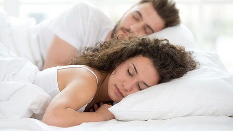 Ein Pärchen liegt im Bett und schläft - Foto: Shutterstock