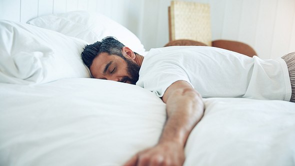 Mann liegt im Bett und schläft - Foto: laflor/iStock