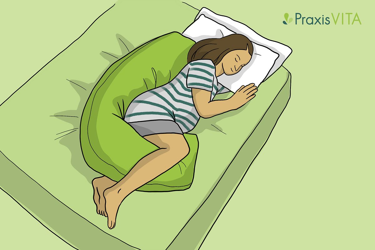 Eine Schwangere schläft auf der linken Seite mit einem Stillkissen