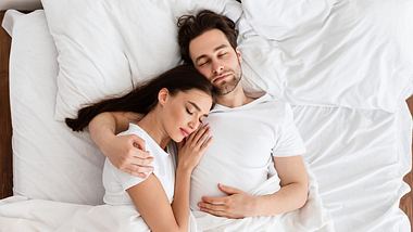 Mann und Frau liegen im Bett - Foto: istock/Prostock-Studio