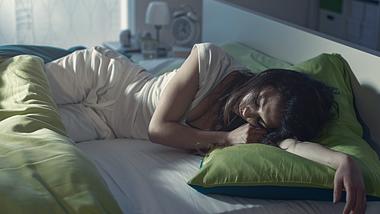 Eine Frau schläft im Bett - Foto: iStock/demaerre