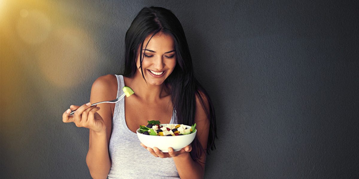 Schlanke Frau isst Salat