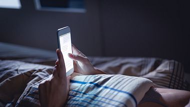 Frau mit Handy im Bett - Foto: iStock/Tero Vesalainen