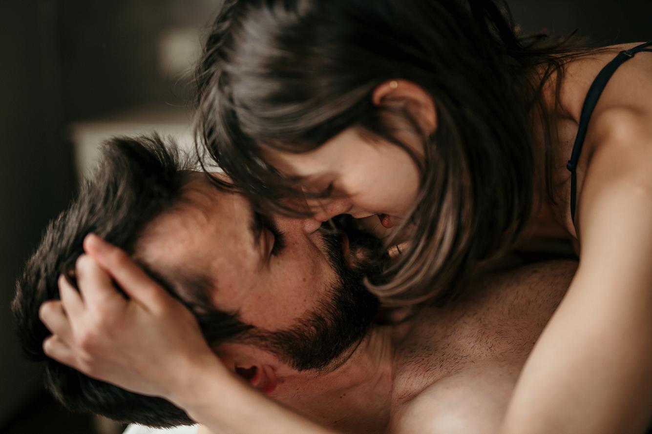 Eine Frau liegt auf einem Mann beim Sex