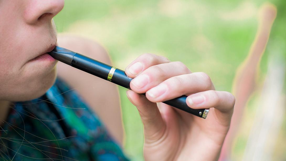 Frau zieht an einer E-Zigarette - Foto: iStock/JANIFEST