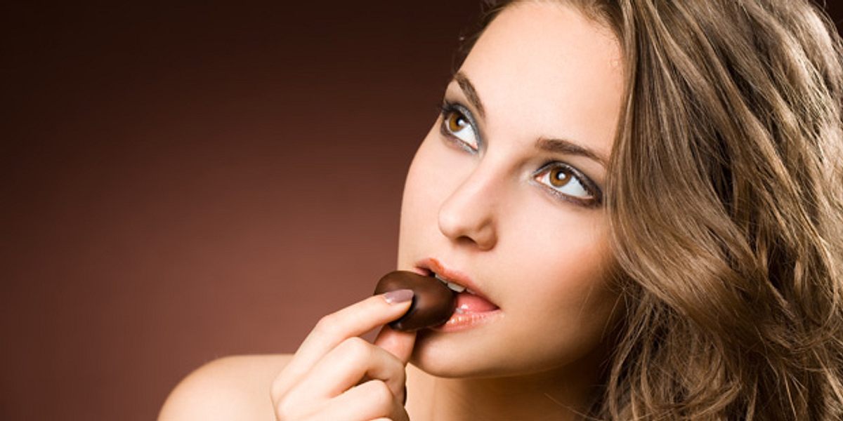 Frau isst Schokolade. Der Inhaltsstoff Flavonol macht schlau