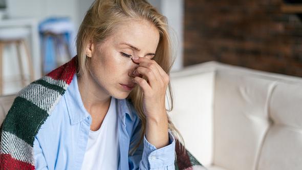 Frau ist müde und hält sich die Hand ans Gesicht - Foto: iStock/brizmaker