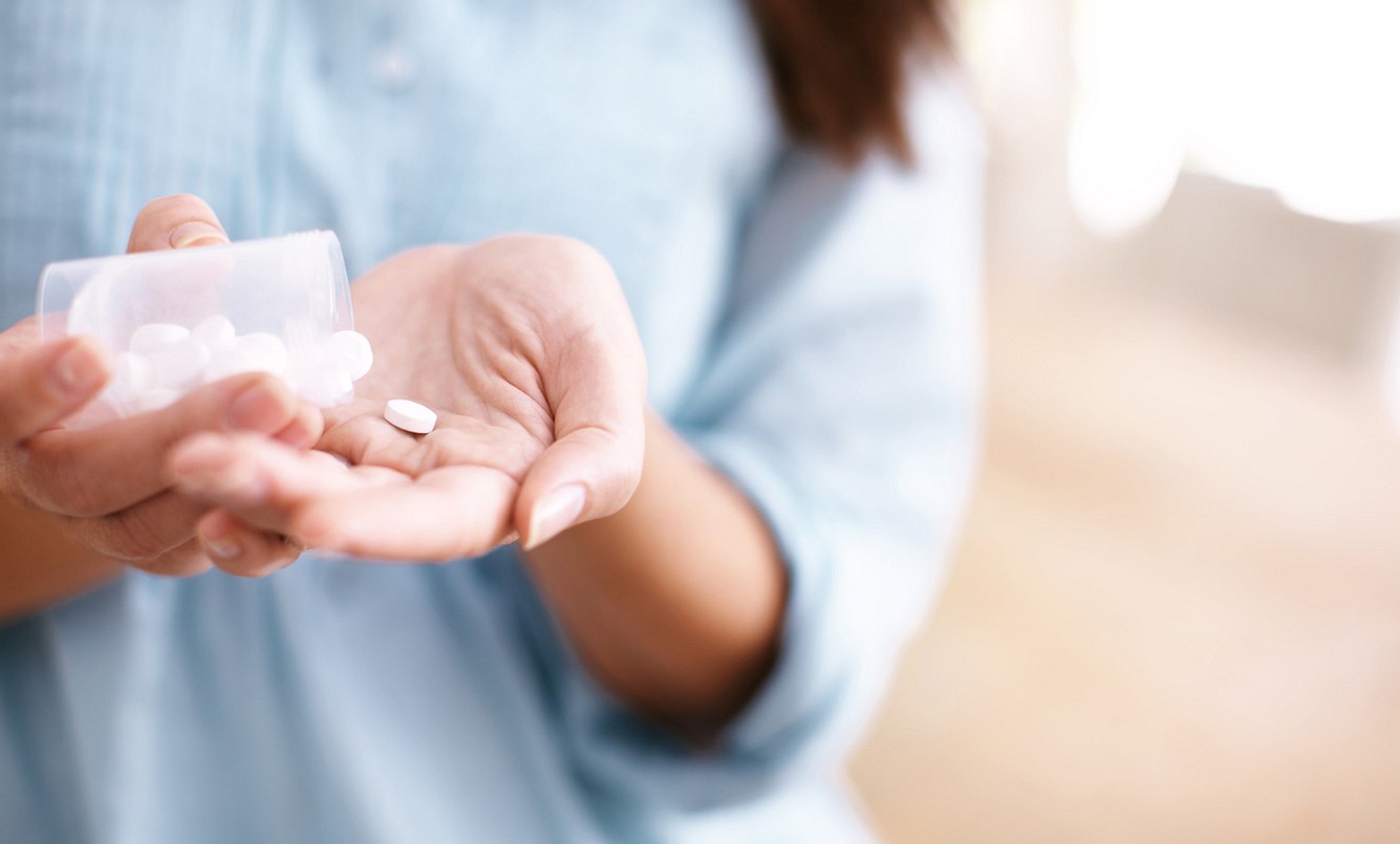 Frau hält Tabletten in der Hand
