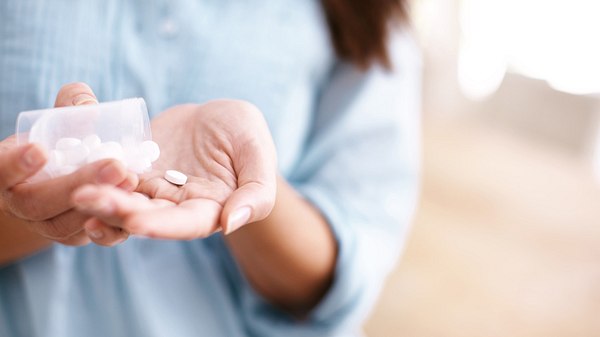 Frau hält Tabletten in der Hand - Foto: istock/-steex