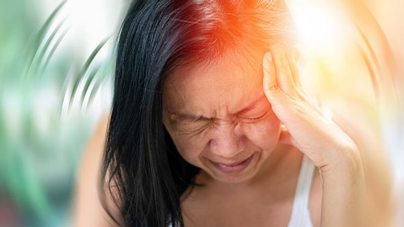 Frau hält sich den Kopf nach Schlaganfall - Foto: iStock/Pornpak Khunatorn