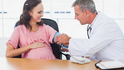 Ein Arzt misst den Blutdruck einer Schwangeren - Foto: Fotolia