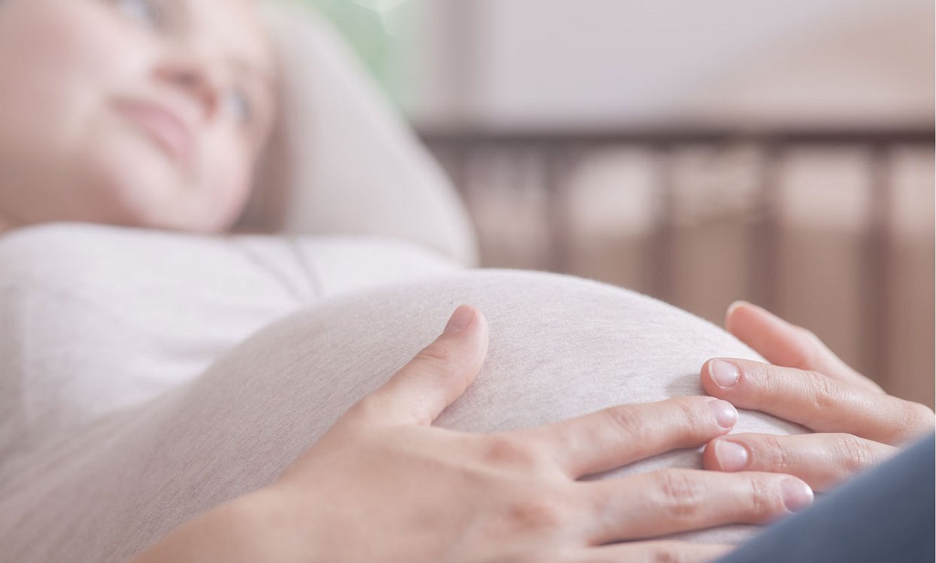 Schwangere legt Hand auf ihren Bauch – SSW 20