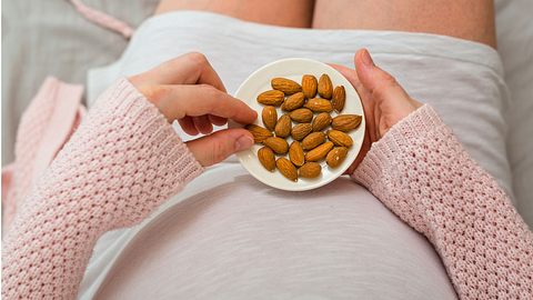 Schwangere isst Mandeln gegen Magnesiummangel in der SSW 22 - Foto: iStock/Dejan_Dundjerski