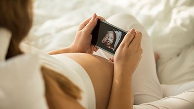 Schwangere schaut sich §D Ultraschallbild an - Foto: iStock/fotostorm