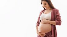 Eine schwanger Frau hält sich den Bauch. - Foto: iStock / Prostock-Studio 