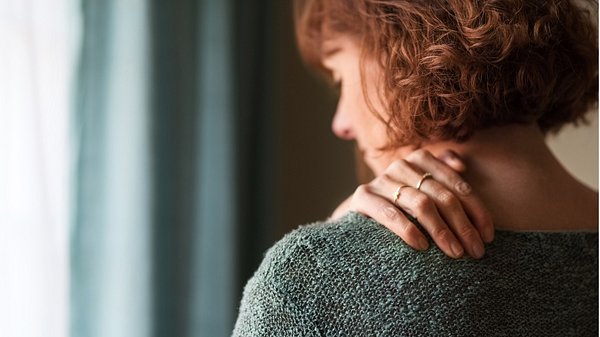 Eine Frau massiert Ihren Nacken - Foto: istock_NickyLloyd