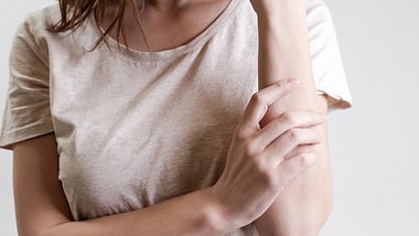 Frau kratzt sich am Arm - Foto: iStock/triocean