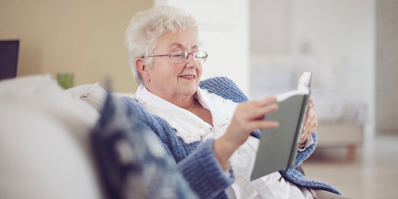 Seniorin mit Demenz liest Buch