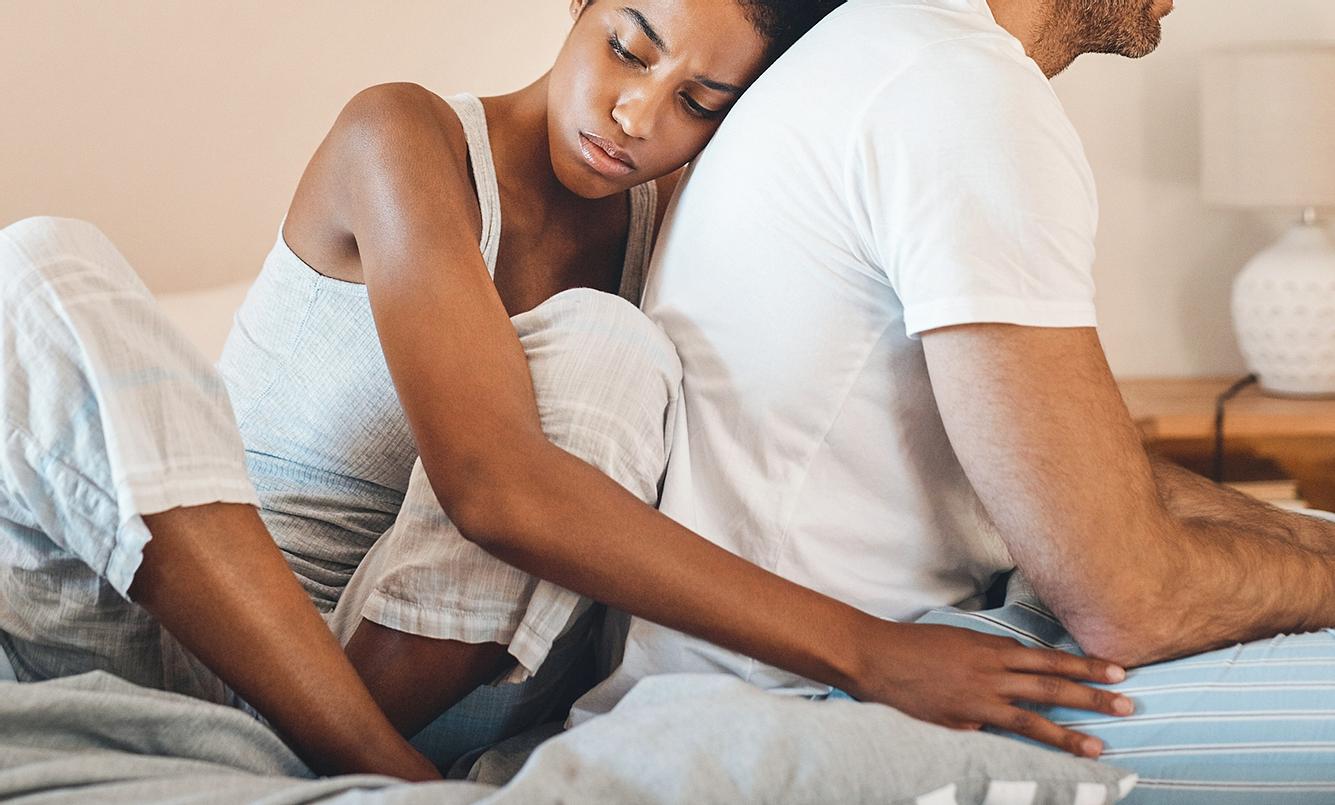 Soll ich mich trennen? Test Eine Frau kuschelt sich an ihren Partner und schaut traurig