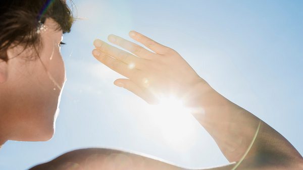 Frau schaut in die Sonne - Foto: Istock/FangXiaNuo