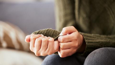 Eine Frau fummelt nervös an ihrem Ärmel herum - Foto: iStock/PeopleImages