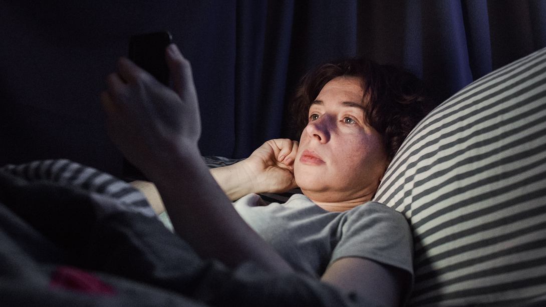 Frau im Bett am Handy - Foto: iStock / invizbk