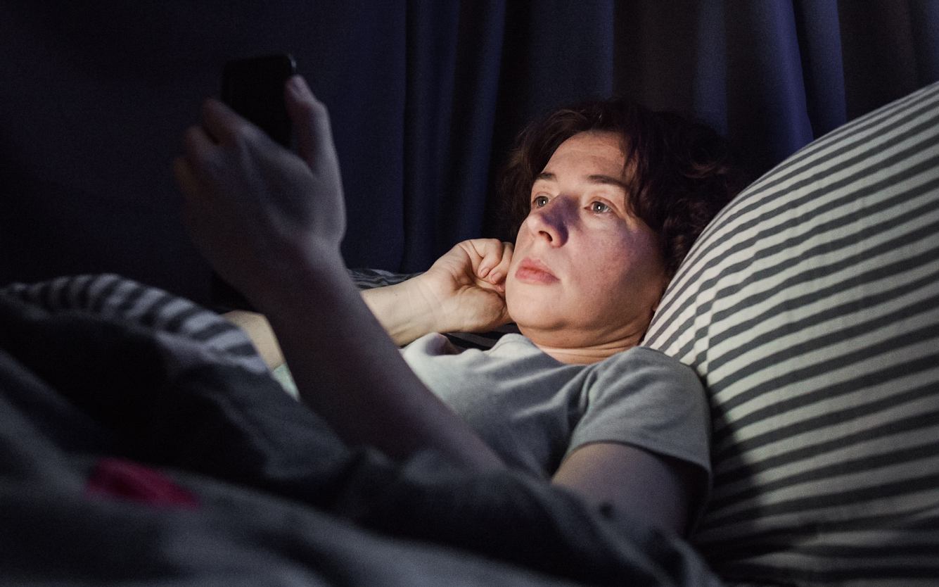 Frau im Bett am Handy