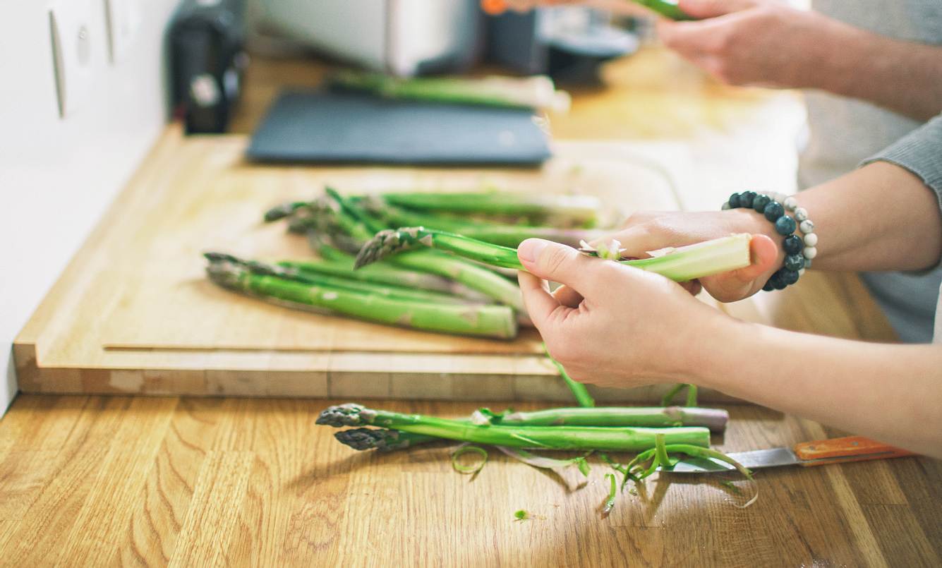 Spargel gesund Grüner Spargel wird in der Küche geschält