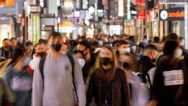 Menschenmenge am Abend mit Maske - Foto: imago images/Future Image